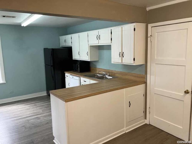 kitchen featuring baseboards, dark wood-style floors, black appliances, white cabinetry, and a sink