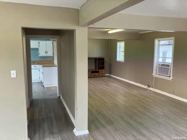 unfurnished room with baseboards, dark wood finished floors, and cooling unit