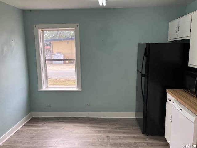 kitchen with baseboards, white cabinets, light wood finished floors, and black appliances