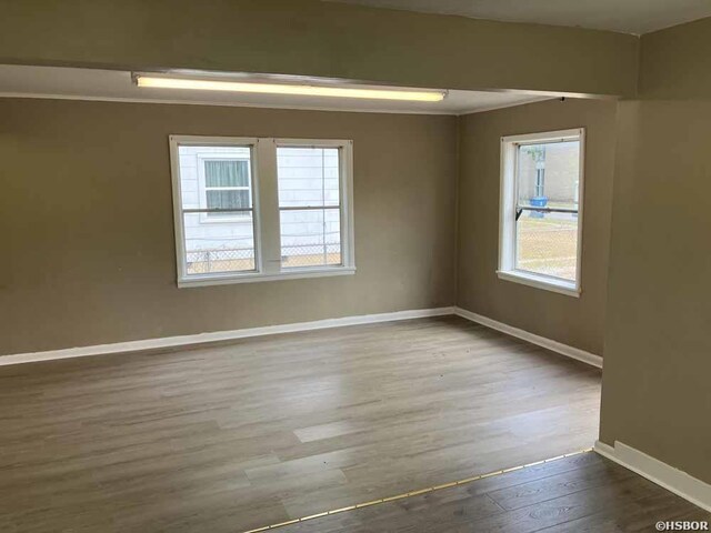 unfurnished room featuring baseboards and wood finished floors