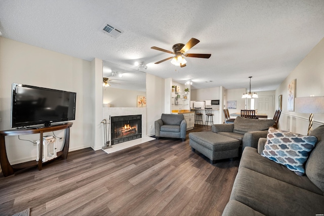 5371 Central Ave Unit 6D, Hot Springs, AR 71913 - living room with ceiling fan, dark wood-style floors, a warm lit fireplace, a textured ceiling, and a chandelier