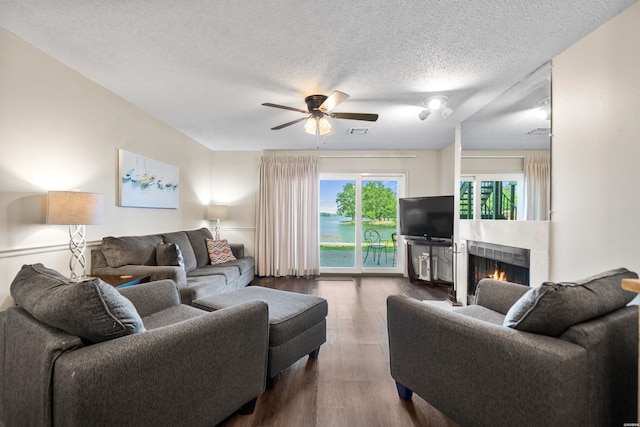 5371 Central Ave Unit 6D, Hot Springs, AR 71913 - living room with dark wood-style flooring, a ceiling fan, a warm lit fireplace, and a textured ceiling