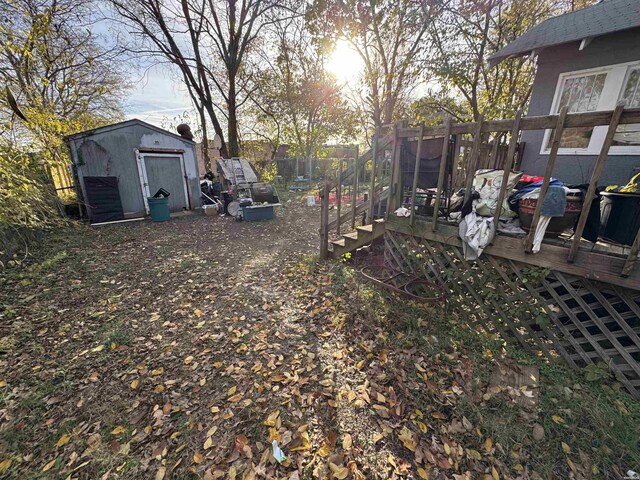 view of yard with an outbuilding, a deck, and a shed