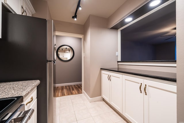 740 Weston Rd Unit 102, Hot Springs, AR 71913 - interior space featuring freestanding refrigerator, white cabinets, light tile patterned flooring, and track lighting