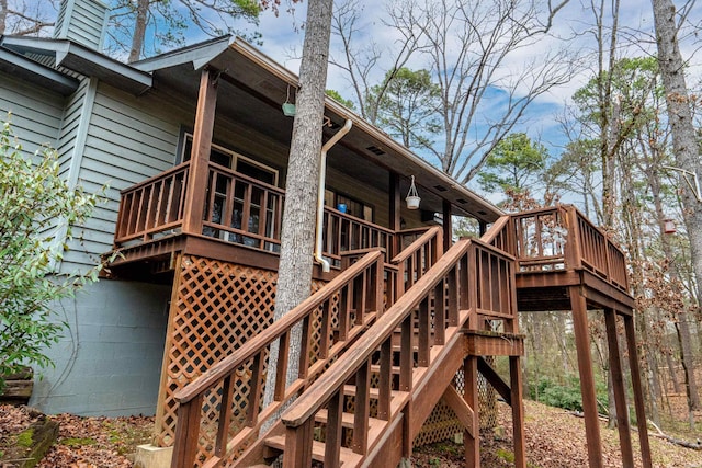 rear view of house featuring stairs and a deck