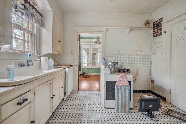 kitchen featuring crown molding, light countertops, light floors, and white cabinets