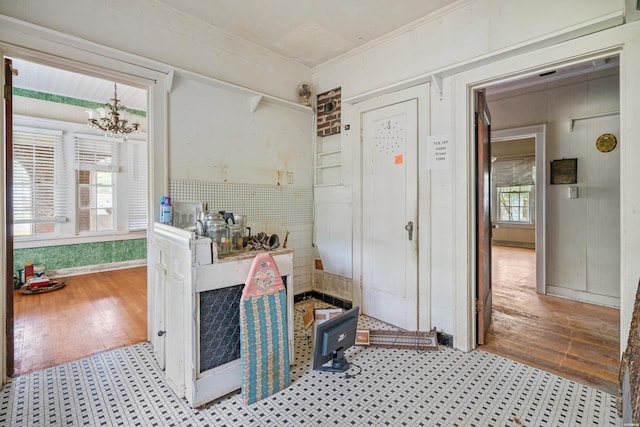 interior space with light wood-type flooring, crown molding, and an inviting chandelier