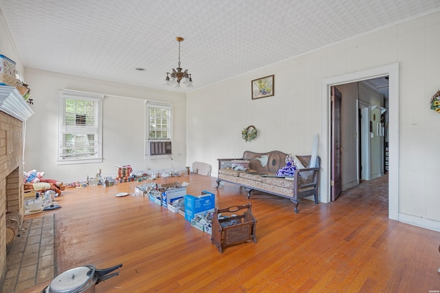 interior space with crown molding, a notable chandelier, a fireplace, and wood finished floors