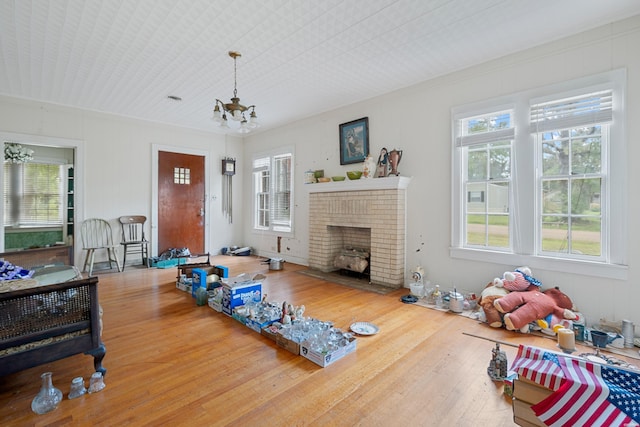 workout area featuring plenty of natural light, wood finished floors, and an inviting chandelier