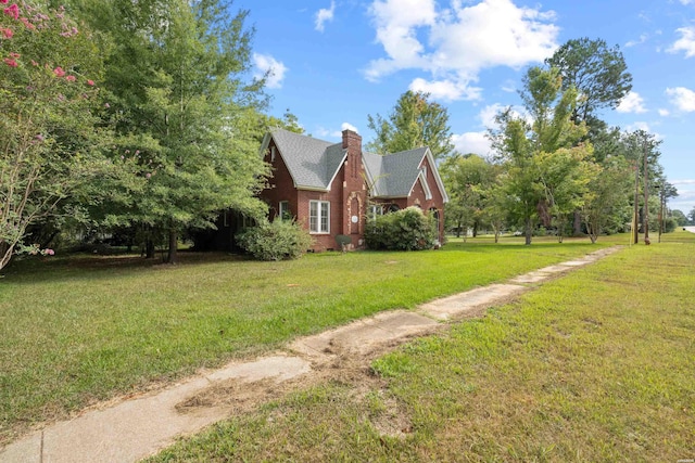 exterior space featuring crawl space, brick siding, a chimney, and a yard