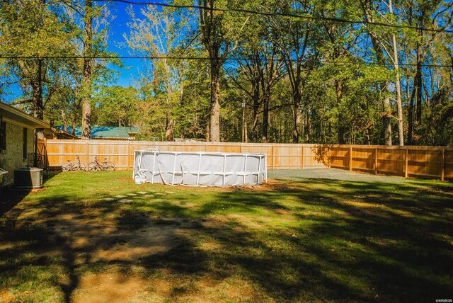 view of yard with a fenced in pool, cooling unit, and a fenced backyard