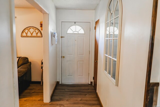 doorway to outside featuring dark wood-style floors and baseboards