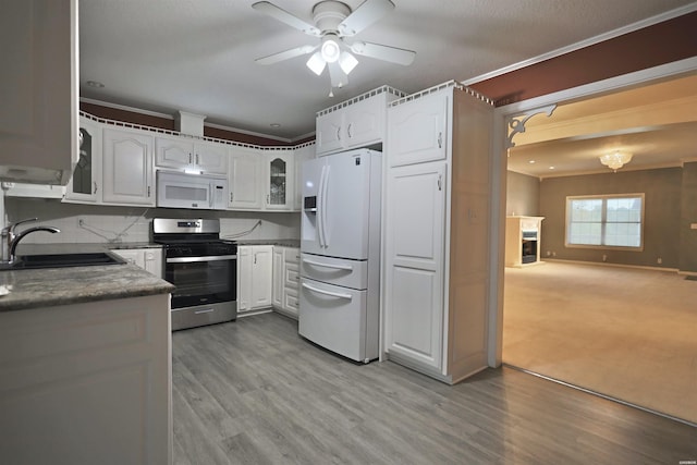 221 Perry St, Glenwood, AR 71943 - kitchen with crown molding, a sink, glass insert cabinets, white appliances, and ceiling fan