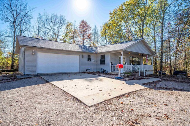 single story home featuring a garage, covered porch, and driveway