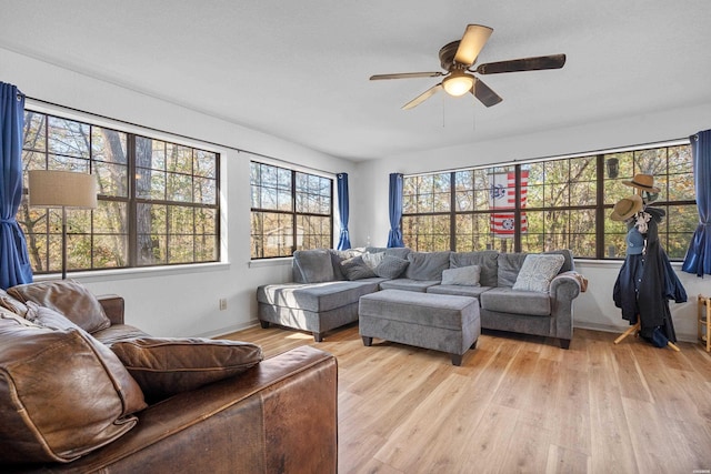 living room with light wood-type flooring and a ceiling fan
