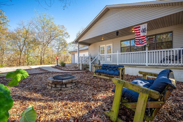 exterior space featuring an outdoor fire pit and covered porch