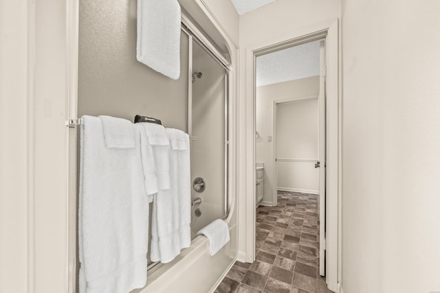 5371 Central Ave Unit 5H, Hot Springs, AR 71913 - bathroom featuring bath / shower combo with glass door and a textured ceiling