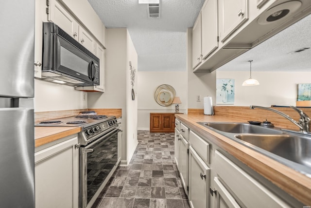 5371 Central Ave Unit 5H, Hot Springs, AR 71913 - kitchen with appliances with stainless steel finishes, a textured ceiling, butcher block counters, white cabinets, and hanging light fixtures