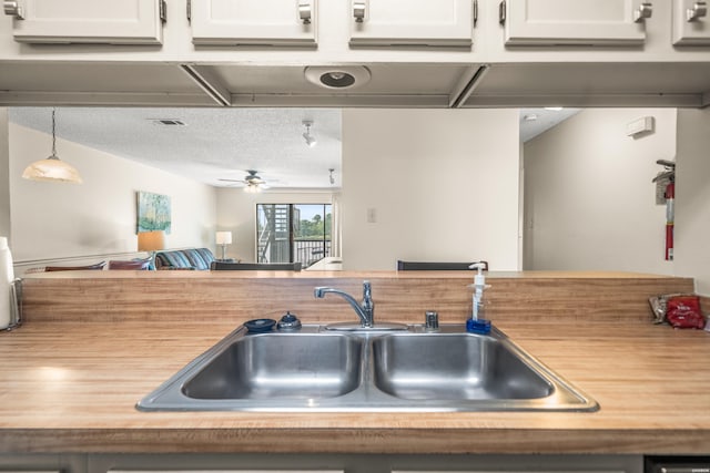 5371 Central Ave Unit 5H, Hot Springs, AR 71913 - kitchen with light countertops, a ceiling fan, white cabinets, a textured ceiling, and decorative light fixtures