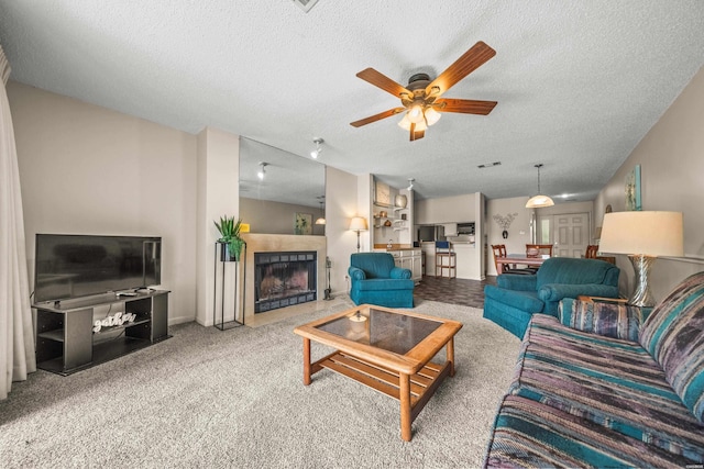 5371 Central Ave Unit 5H, Hot Springs, AR 71913 - living room featuring a textured ceiling, ceiling fan, a tile fireplace, and carpet flooring