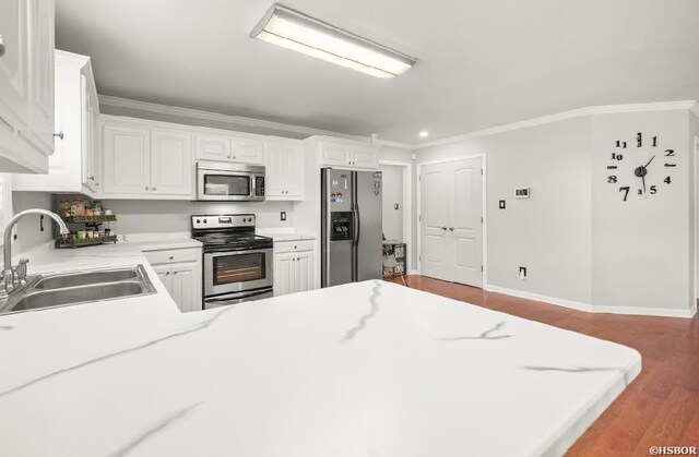 136 Ami Jo Dr, Hot Springs, AR 71913 - kitchen with stainless steel appliances, a sink, wood finished floors, light countertops, and crown molding