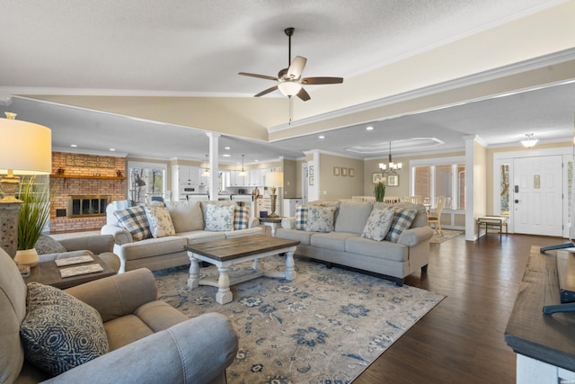 living room with a fireplace, crown molding, decorative columns, lofted ceiling, and dark wood-type flooring