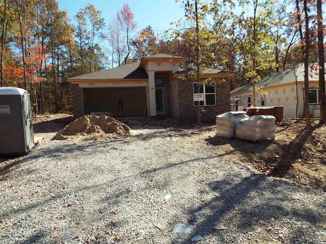 view of front of house featuring driveway, brick siding, and an attached garage