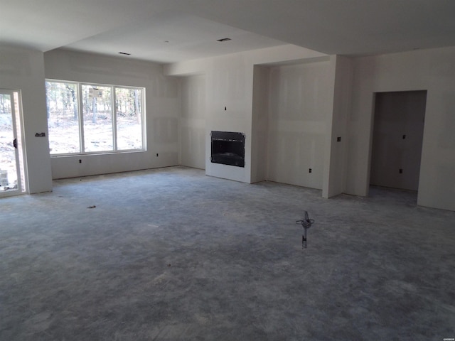 unfurnished living room featuring carpet floors, heating unit, and a fireplace