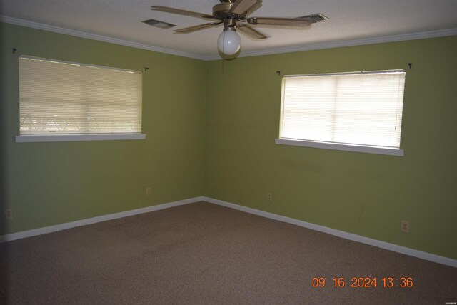 carpeted empty room with ceiling fan, ornamental molding, and baseboards