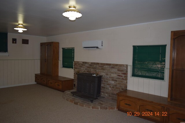 unfurnished living room featuring carpet, a wainscoted wall, a wall unit AC, and crown molding