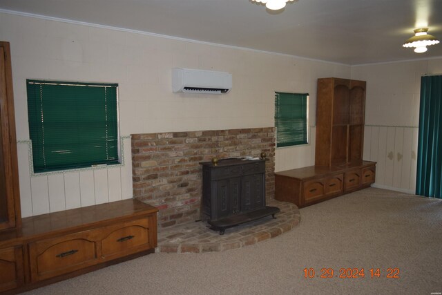 living room with ornamental molding, a wood stove, light carpet, and a wall mounted AC