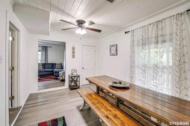 dining space with ceiling fan, wooden ceiling, wood finished floors, and crown molding