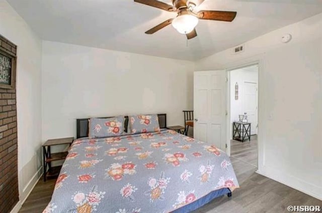 bedroom featuring baseboards, visible vents, and wood finished floors