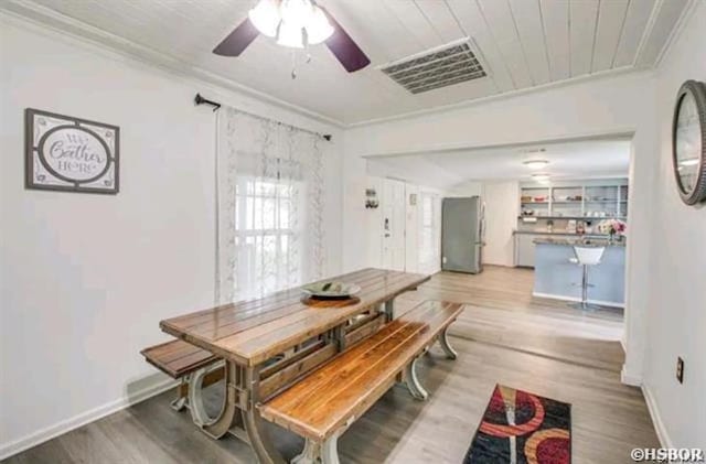 dining area with ornamental molding, visible vents, and wood finished floors