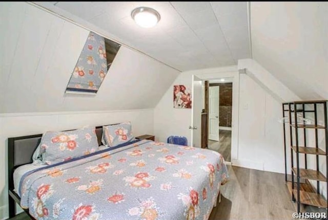 bedroom featuring lofted ceiling and wood finished floors