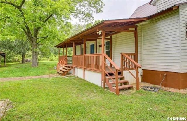 exterior space featuring covered porch and a yard