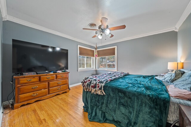 bedroom featuring ceiling fan, crown molding, baseboards, and wood finished floors