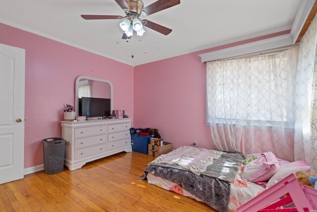 bedroom featuring baseboards, light wood finished floors, a ceiling fan, and crown molding