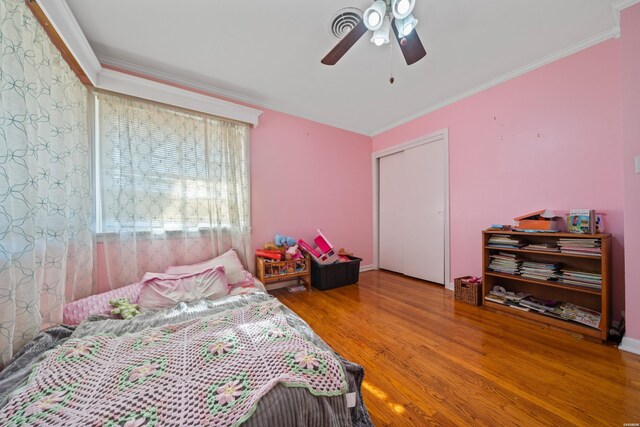 bedroom featuring ceiling fan, crown molding, and wood finished floors