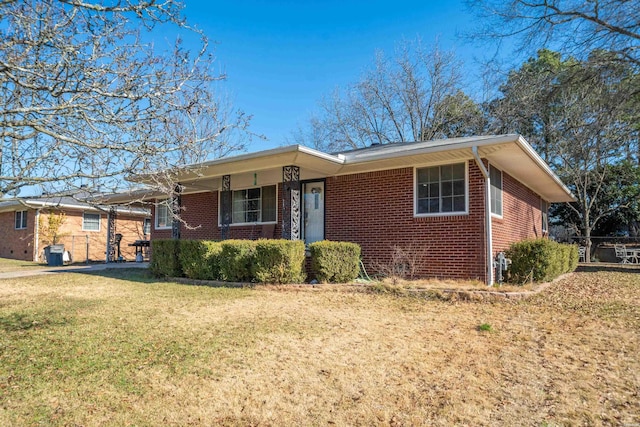 ranch-style house featuring brick siding and a front lawn