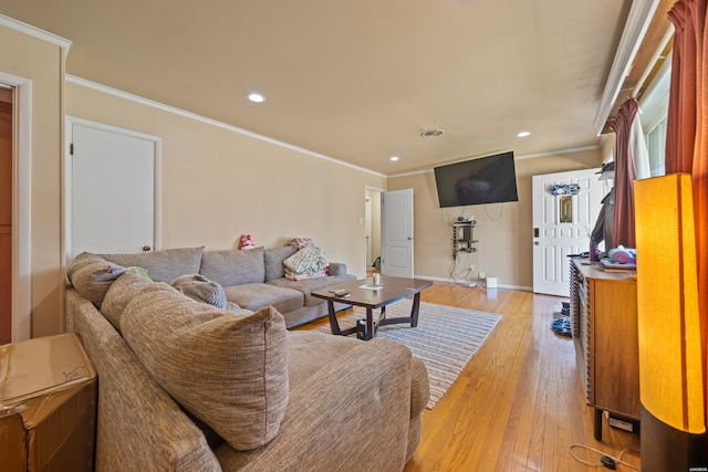 living room with light wood-style floors, baseboards, crown molding, and recessed lighting