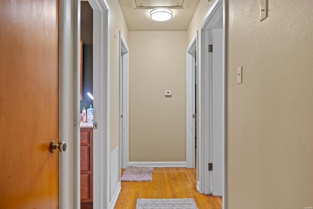 hallway with light wood-style floors and baseboards