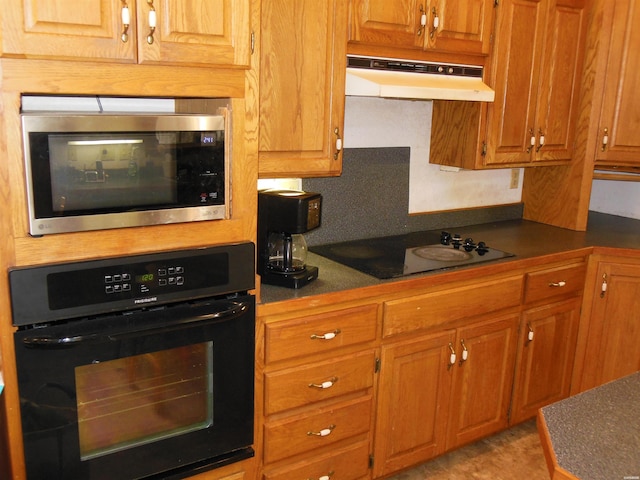 kitchen featuring black appliances, under cabinet range hood, and brown cabinets