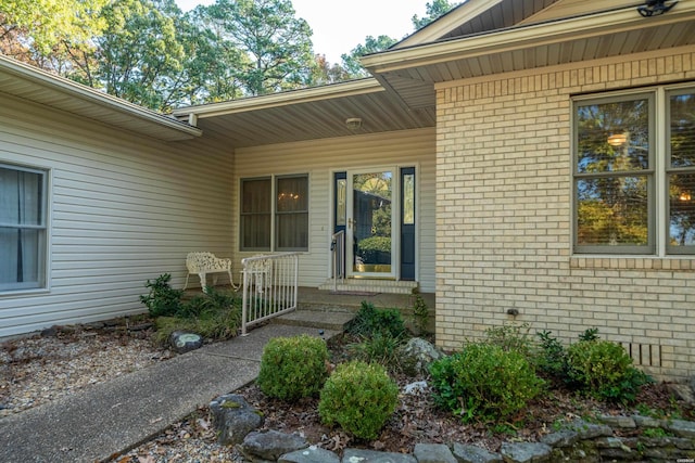 view of exterior entry featuring brick siding