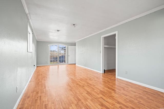 unfurnished room featuring crown molding, visible vents, baseboards, and light wood finished floors