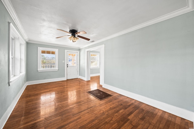 empty room featuring baseboards, a ceiling fan, wood-type flooring, and crown molding