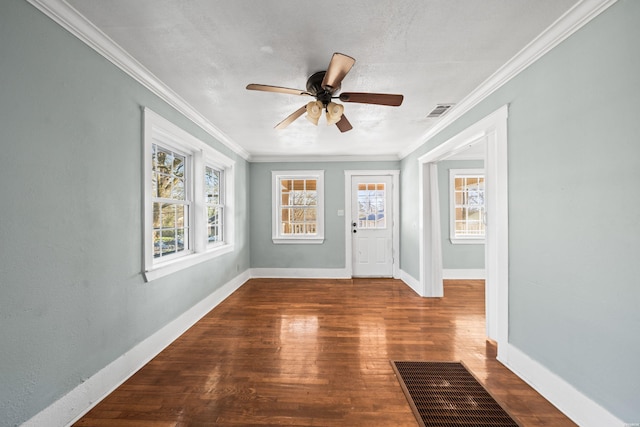 spare room featuring a ceiling fan, crown molding, wood finished floors, and visible vents