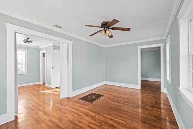 spare room featuring baseboards, visible vents, ceiling fan, hardwood / wood-style flooring, and crown molding