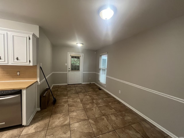 22 Irish Rose Cir, Alexander, AR 72002 - kitchen with stainless steel dishwasher, white cabinetry, light countertops, tile patterned floors, and baseboards