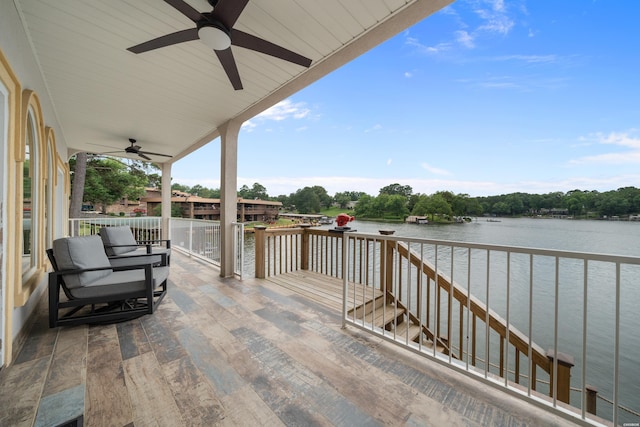 wooden terrace with a ceiling fan and a water view